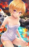  1girl autumn_leaves bangs bare_arms bare_shoulders blonde_hair blurry blurry_background blush breasts collarbone commentary_request covered_navel depth_of_field eyebrows_visible_through_hair feet_out_of_frame fence hair_between_eyes highres idolmaster idolmaster_shiny_colors leaf looking_at_viewer maple_leaf naked_towel night onsen outdoors parted_lips purple_eyes revision saijou_juri short_hair small_breasts solo towel urabi_(tomatohouse) water 