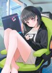  1girl bangs barefoot black_hair black_jacket blurry blurry_background breasts chair closed_mouth commentary_request computer crossed_legs depth_of_field drawstring eyebrows_visible_through_hair feet_out_of_frame grey_shorts hair_ornament hairclip head_tilt highres hood hood_down hooded_jacket hyuuga_azuri indoors jacket knees_up laptop long_sleeves looking_at_viewer medium_breasts office_chair on_chair original red_eyes shirt short_shorts shorts sleeves_past_wrists solo white_shirt window 