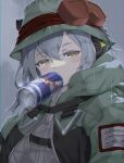  1girl absurdres bangs blush_stickers bucket_hat coat g11_(girls&#039;_frontline) girls&#039;_frontline goggles goggles_on_headwear green_coat green_headwear grey_shirt greyscale half-closed_eyes hat headphones highres hooded_coat kagami_(haret46) long_hair looking_at_viewer mod3_(girls&#039;_frontline) monochrome mouth_hold rain red_bull shirt solo upper_body yellow_eyes 