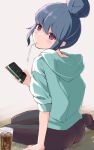  1girl ass blue_hair blush cellphone drink drinking_straw file112056 green_hoodie highres holding holding_phone hood hoodie looking_at_viewer looking_back on_floor pantyhose phone purple_eyes shima_rin simple_background sitting smartphone sweater yurucamp 