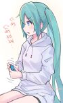  1girl blue_eyes blue_hair blush controller game_controller hatsune_miku highres holding holding_controller holding_game_controller hood hoodie long_hair long_sleeves open_mouth short_shorts shorts sitting solo translation_request twintails v-shaped_eyebrows very_long_hair vocaloid yasuno-labo 
