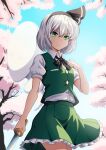  1girl absurdres black_hairband blue_sky cherry_blossoms closed_mouth ghost green_eyes green_skirt green_vest grey_hair hairband highres konpaku_youmu konpaku_youmu_(ghost) outdoors shirt short_hair short_sleeves skirt sky smacphadraig solo touhou vest white_shirt youmu_day 