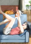  1girl barefoot black_hair blush brick_wall cat couch furniture highres indoors long_hair loungewear lying on_back on_couch open_mouth original patterned_clothing pink_shirt plant round_teeth shirt shorts sleeveless smile soragane_(banisinngurei) teeth window wooden_floor 