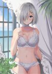  1girl blue_eyes blue_sky blush bra breasts choker cleavage collarbone commentary day frilled_bra frilled_panties frills hair_ornament hair_over_one_eye hairclip hamakaze_(kancolle) hand_on_own_chest highres indoors kantai_collection large_breasts lingerie looking_at_viewer natsume_(natsume_melio) panties short_hair silver_bra silver_hair silver_panties sky smile solo underwear window 