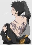  1boy black_hair chibisuke coat_partially_removed facial_hair from_above grey_eyes long_sleeves looking_back male_focus one_piece partially_undressed simple_background solo tattoo trafalgar_law 