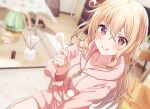  1girl bangs blonde_hair blurry blurry_background blush collarbone couch hand_up highres holding hood hoodie indoors licking_lips long_hair long_sleeves looking_at_viewer mimikaki original pink_hoodie red_eyes shiokazunoko sitting smile solo table tongue tongue_out 