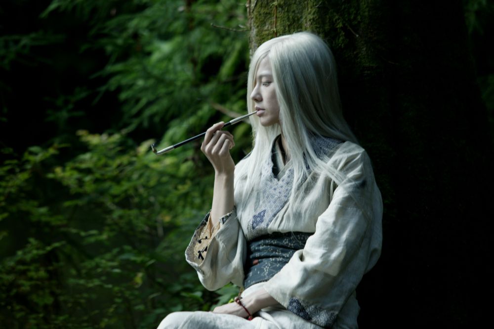 closed_eyes holding holding_pipe japanese_clothes kimono live_action long_sleeves mushishi nui_(mushishi) photo pipe pipe_in_mouth screencap silver_hair solo