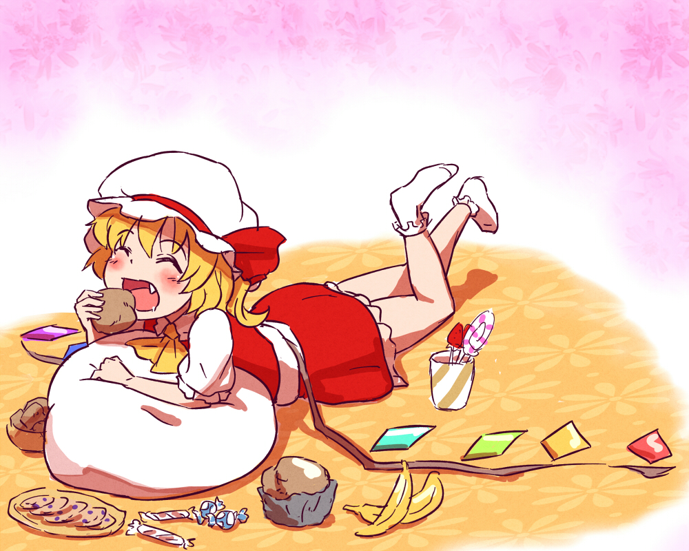 ascot banana bat_wings blonde_hair blush candy closed_eyes cookie cup eating fang flandre_scarlet food fruit hat holding lollipop lying muffin on_stomach open_mouth pillow plate shibasaki_shouji short_hair skirt smile solo touhou wings