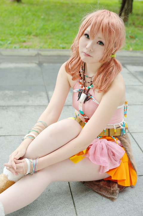 belt boots bracelet cosplay female final_fantasy final_fantasy_xiii grass jewelry looking_at_viewer midriff necklace oerba_dia_vanille oerba_dia_vanille_(cosplay) on_floor outdoors pink_shirt shirt sitting skirt solo tile tiles twintails