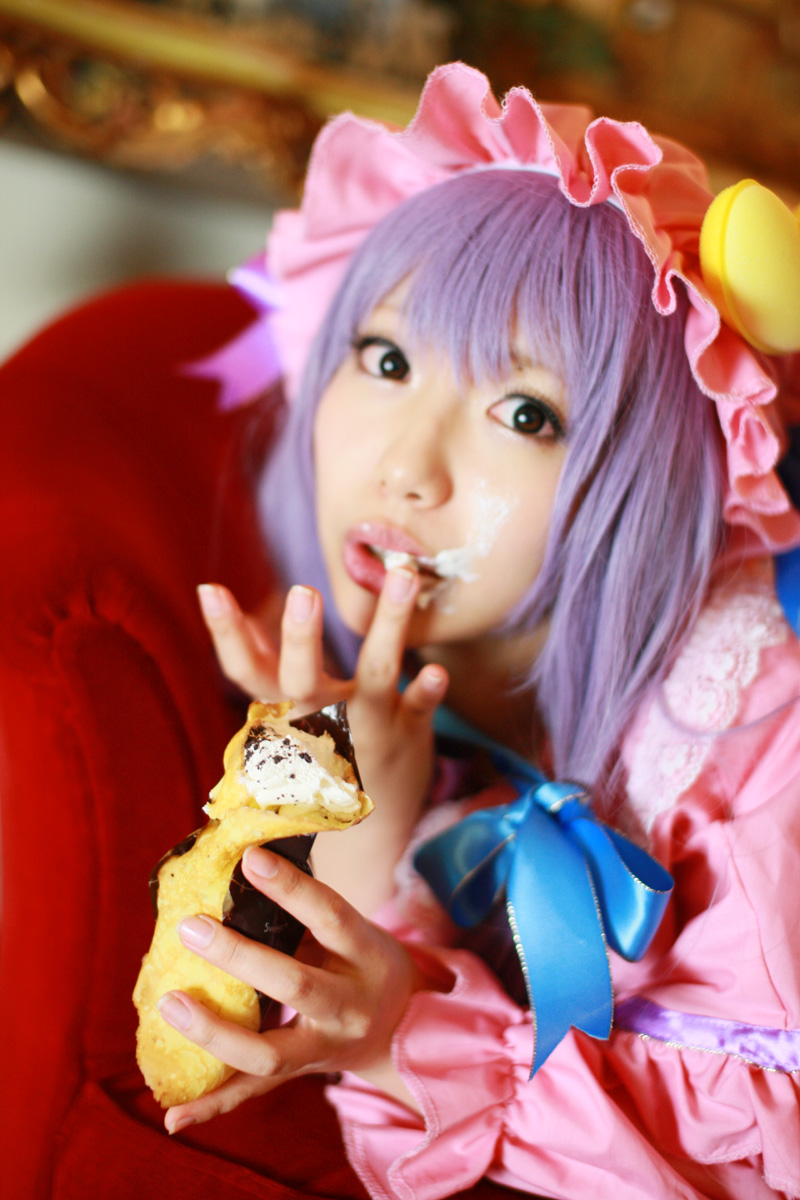 1girl asian cosplay couch cream crescent dessert dress female food hat highres long_hair patchouli_knowledge photo purple_hair solo tenshi_myu touhou