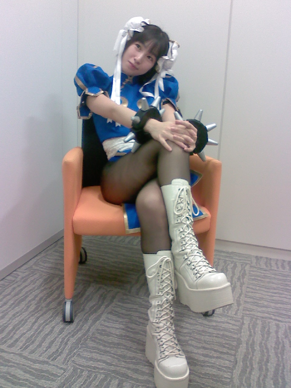 boots bun_cover chun-li cosplay crossed_legs double_bun highres non-web_source pantyhose photo sitting solo street_fighter