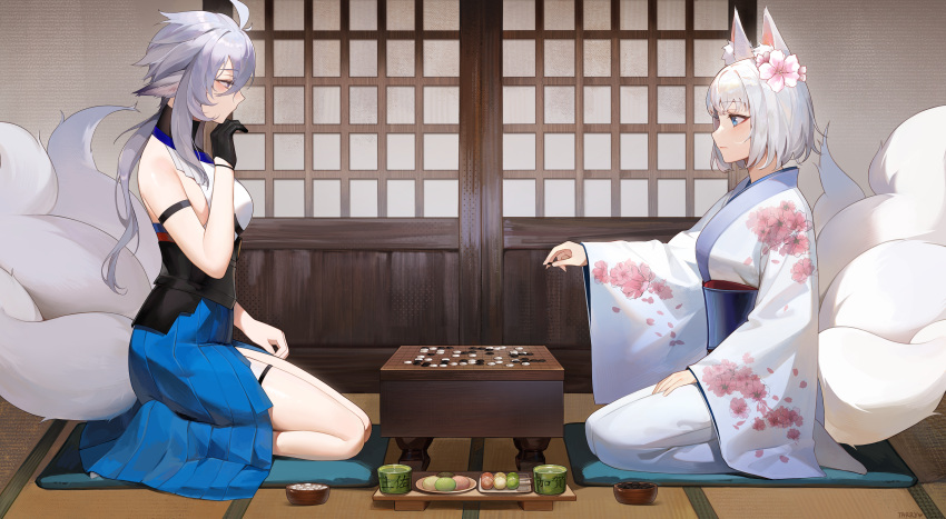 2girls absurdres animal_ears asymmetrical_skirt azur_lane bare_shoulders black_gloves blue_eyes blue_sash blue_skirt board_game cup cushion english_commentary floral_print_kimono flower fox_ears fox_girl from_side gloves go_(board_game) grey_hair hair_between_eyes hair_flower hair_ornament highres indoors japanese_clothes kaga_(azur_lane) kaga_(gentle_blossom's_sigh)_(azur_lane) kimono kitsune kyuubi large_tail long_sleeves multiple_girls multiple_tails official_alternate_costume pink_flower sash seiza short_hair short_hair_with_long_locks siblings sisters sitting skirt tail tarry tea teacup thigh_strap tosa_(azur_lane) white_hair white_kimono white_tail wide_sleeves zabuton