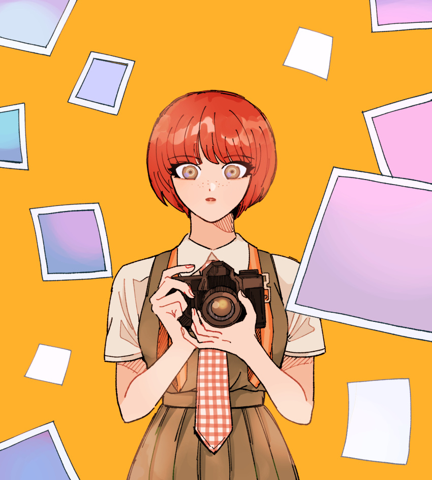 1girl bangs brown_eyes brown_shirt camera danganronpa_(series) danganronpa_2:_goodbye_despair dress freckles green_dress hands_up highres holding holding_camera koizumi_mahiru looking_at_viewer necktie okonomiyakiyyy1 orange_background photo_(object) pinafore_dress plaid_necktie pleated_dress red_hair red_necktie shiny shiny_hair shirt short_hair short_sleeves solo white_necktie