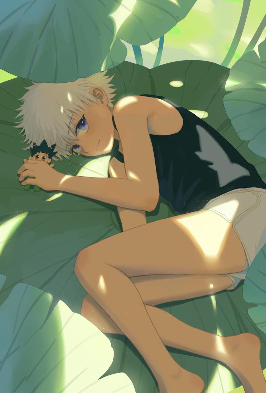 1boy absurdres bangs bare_arms bare_legs bare_shoulders barefoot blue_eyes blush character_doll commentary dappled_sunlight day feet_out_of_frame from_above gon_freecss highres holding hunter_x_hunter killua_zoldyck leaf looking_at_viewer looking_up luye_yuan lying male_focus nature on_side shorts sideways_glance sleeveless smile solo spiked_hair sunlight symbol-only_commentary tank_top white_hair white_shorts