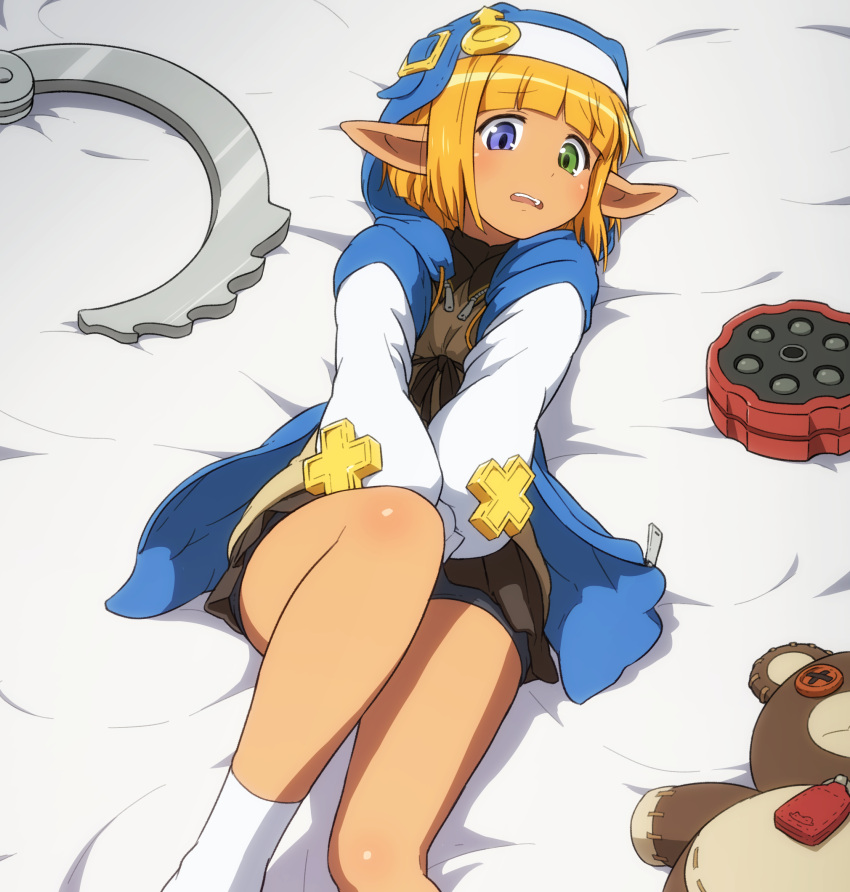 1boy bangs bed_sheet bike_shorts_under_skirt black_skirt blonde_hair blue_eyes blunt_bangs bridget_(guilty_gear) bridget_(guilty_gear)_(cosplay) button_eyes commentary_request cosplay covering covering_crotch cuffs green_eyes guilty_gear handcuffs heterochromia highres hood hood_up long_sleeves lying male_focus mare_bello_fiore mars_symbol on_back open_mouth otoko_no_ko overlord_(maruyama) oversized_object pleated_skirt pointy_ears shirosato skirt socks solo stuffed_animal stuffed_toy teddy_bear