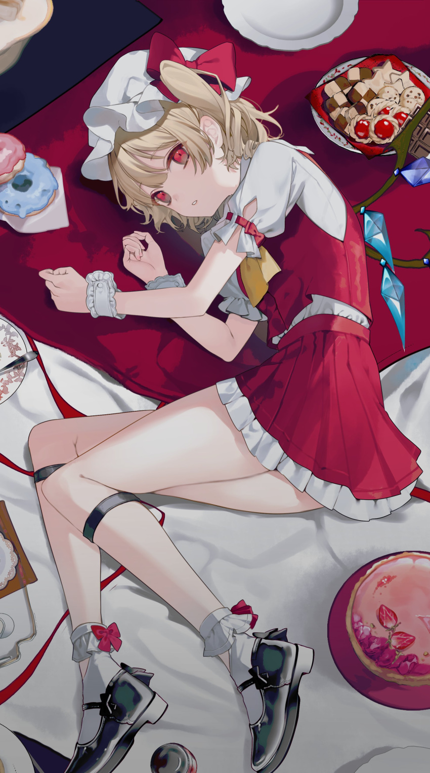 1girl absurdres ascot black_footwear blonde_hair bobby_socks bow cake checkerboard_cookie chocolate cookie crystal curled_up daimaou_ruaeru doughnut flandre_scarlet food frilled_skirt frilled_sleeves frills fruit full_body hat hat_bow highres looking_at_viewer lying mary_janes medium_hair mob_cap on_side one_side_up parted_lips plate red_bow red_eyes red_skirt red_vest shirt shoes short_sleeves skirt socks solo strawberry tablecloth touhou vest white_headwear white_shirt white_socks wings wrist_cuffs yellow_ascot