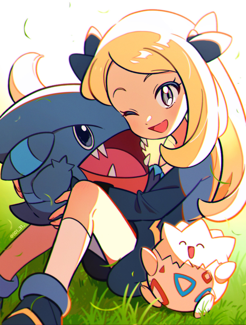 1girl ;d absurdres aged_down black_dress black_footwear black_ribbon blonde_hair blush chueog cynthia_(pokemon) dress eyelashes falling_leaves gible grass grey_eyes hair_ribbon happy highres holding holding_pokemon leaf long_hair long_sleeves one_eye_closed open_mouth pokemon pokemon_(anime) pokemon_(creature) pokemon_journeys ribbon shoes sitting smile socks togepi tongue white_socks young_cynthia_(pokemon)