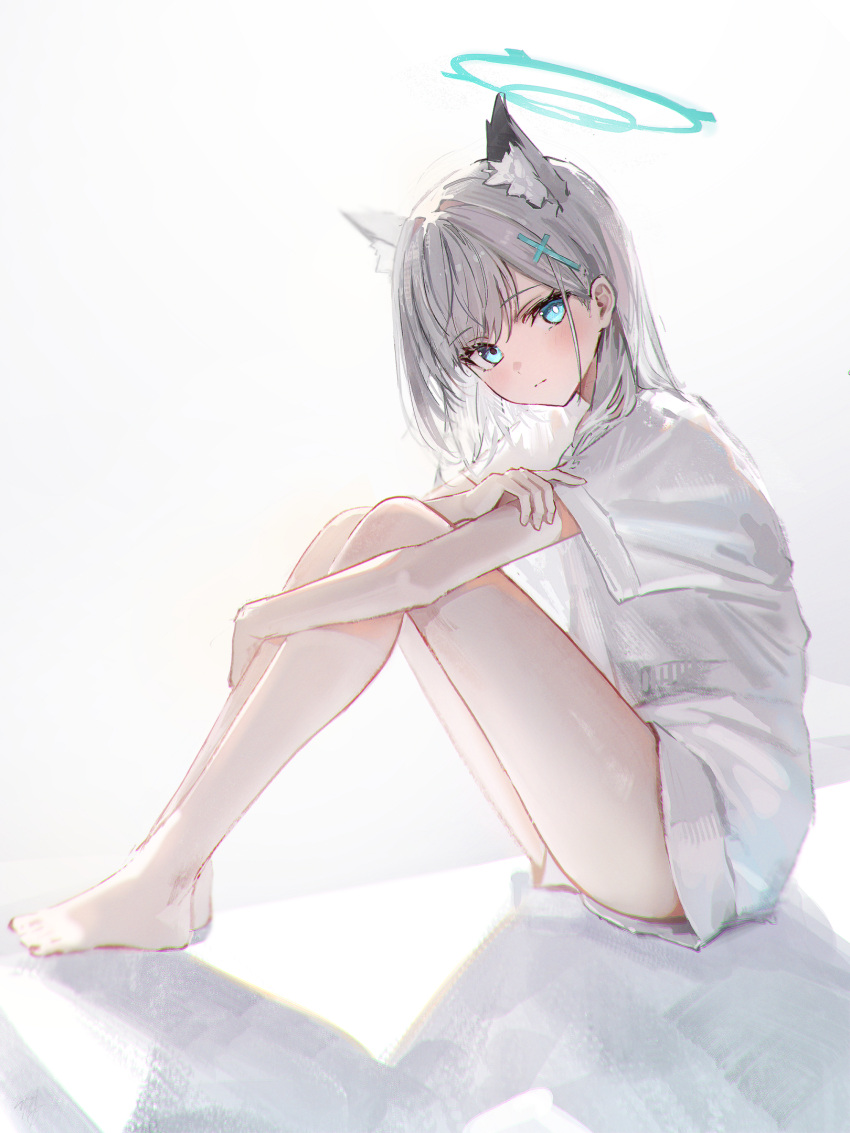 1girl alternate_costume animal_ear_fluff animal_ears bare_legs barefoot blue_archive blue_eyes blue_halo blush bright_pupils closed_mouth commentary cross_hair_ornament extra_ears from_side full_body grey_hair hair_ornament halo hidulume highres hugging_own_legs knees_up looking_at_viewer mismatched_pupils shiroko_(blue_archive) shirt short_hair short_sleeves simple_background sitting solo thighs white_background white_pupils white_shirt wolf_ears wolf_girl