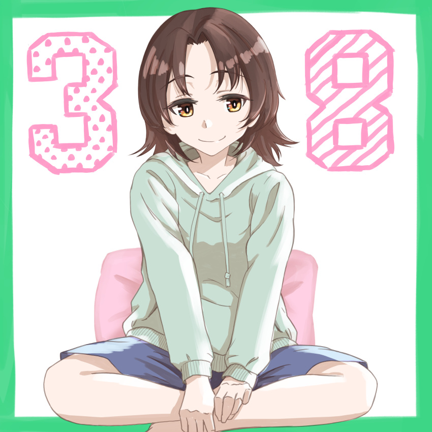1girl absurdres bangs blue_shorts border brown_eyes brown_hair casual closed_mouth commentary drawstring girls_und_panzer green_border green_hoodie highres hood hood_down hoodie indian_style looking_at_viewer oritako parted_bangs pillow sawa_azusa short_hair shorts sitting smile solo