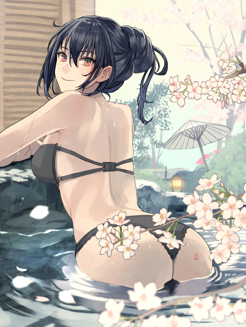 1girl arched_back arm_rest ass back bangs bare_shoulders bathing bikini black_bikini black_hair branch breasts bush cherry_blossoms closed_mouth flower from_behind hair_between_eyes highres kantai_collection kasumi_(skchkko) lamp large_breasts looking_at_viewer looking_back nagato_(kancolle) oil-paper_umbrella onsen outdoors petals petals_on_liquid red_eyes smile solo swimsuit tree umbrella water wet