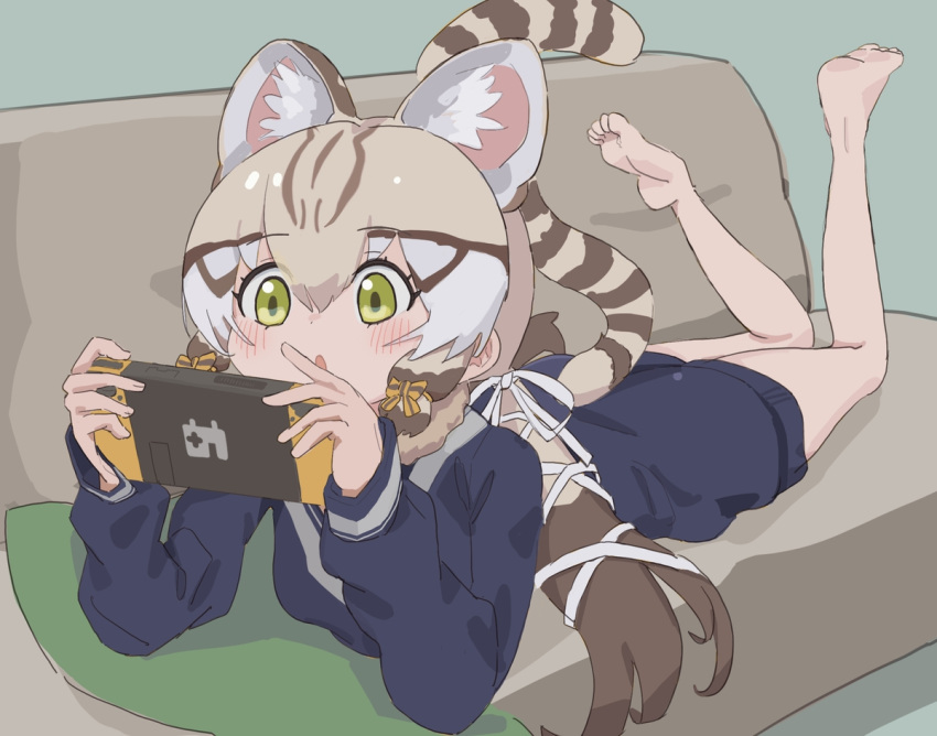 1girl animal_ears bare_legs barefoot blonde_hair blue_sweater blush bow brown_hair cat_ears cat_girl cat_tail commentary extra_ears geoffroy's_cat_(kemono_friends) green_eyes hair_bow kemono_friends kunikuni_(kunihiro2005) long_hair long_sleeves lying multicolored_hair nintendo_switch on_stomach sailor_collar school_uniform sidelocks solo sweater symbol-only_commentary tail the_pose twintails white_bow