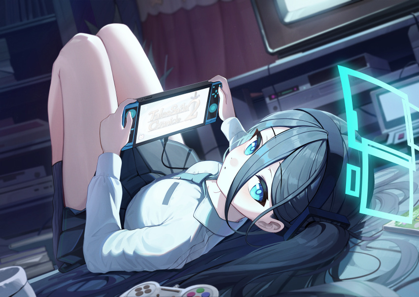 1girl :o aris_(blue_archive) black_hair black_hairband black_skirt blue_archive blue_eyes blue_necktie commentary controller game_controller hair_between_eyes hairband halo handheld_game_console highres holding holding_handheld_game_console hutosutoro indoors long_hair long_sleeves looking_at_viewer lying necktie on_back shirt side_ponytail skirt solo thighs very_long_hair white_shirt