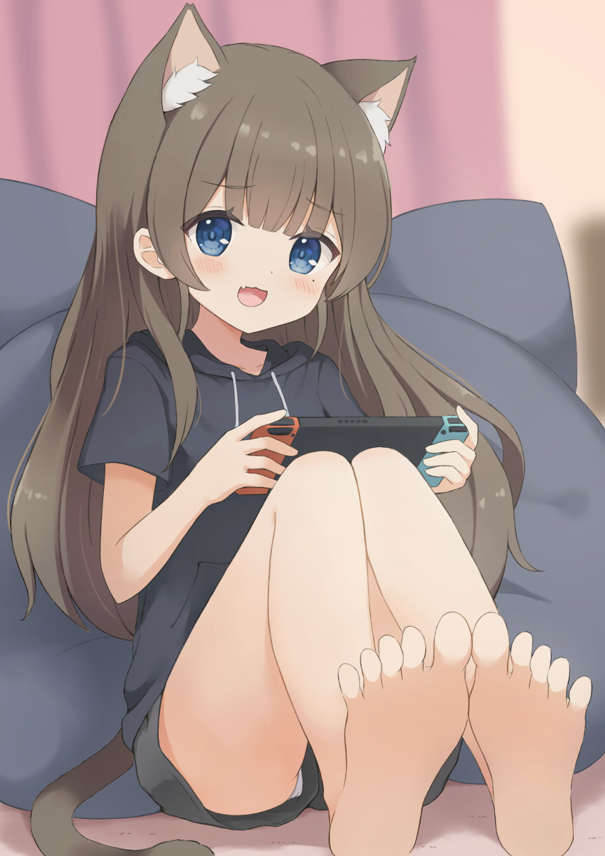 1girl :3 absurdres animal_ears barefoot blue_eyes blurry blurry_background blush brown_hair cat_ears cat_girl cat_tail curtains feet foot_focus hair_down handheld_game_console highres holding holding_handheld_game_console hood hoodie indie_virtual_youtuber indoors itigori_ena knees_up looking_at_viewer mole mole_under_eye nintendo_switch open_mouth panties panty_peek pantyshot pillow short_sleeves shorts sitting solo tail tyakomis underwear virtual_youtuber