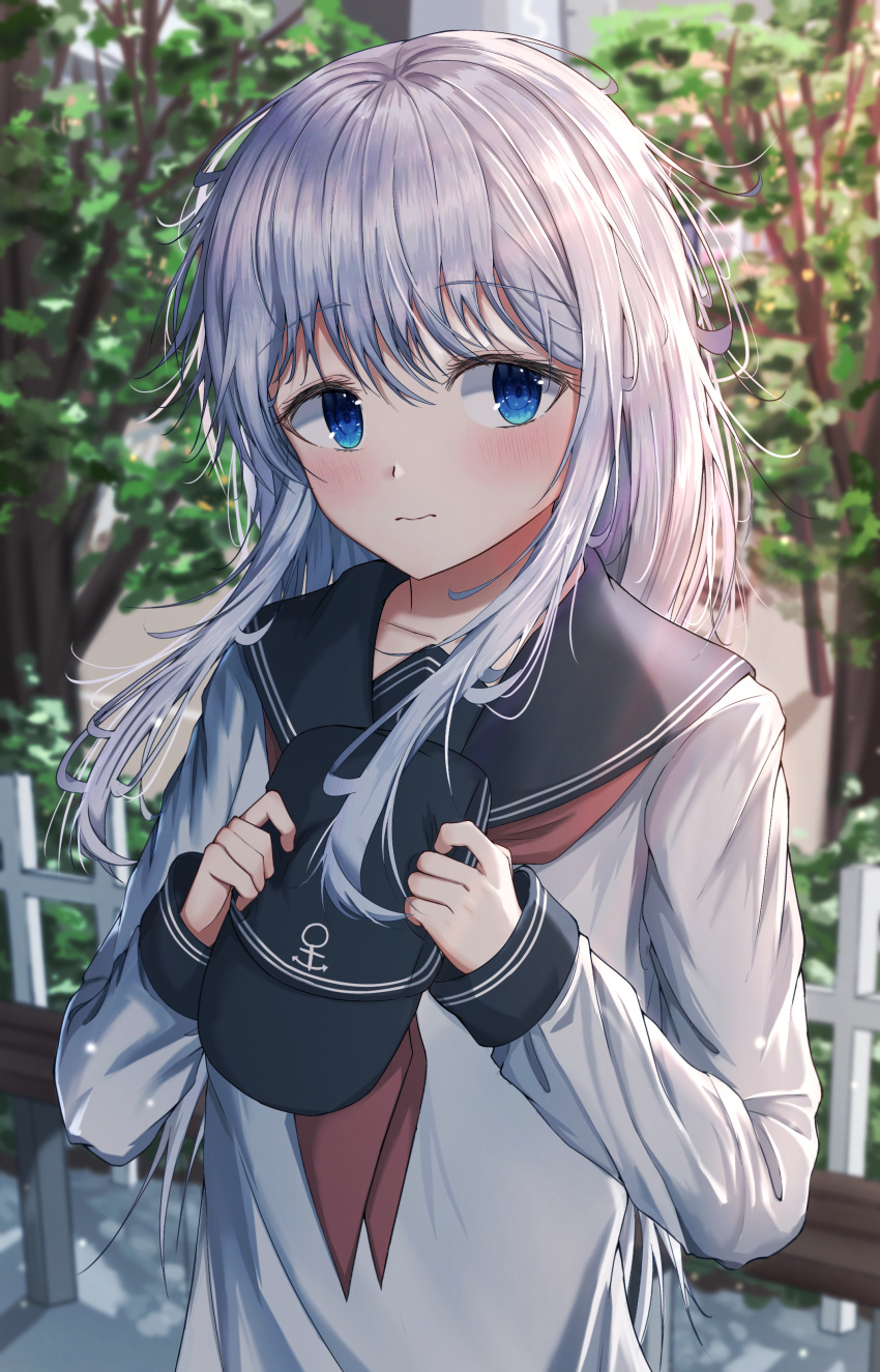1girl absurdres anchor_symbol bench blue_eyes blush collarbone dfd fence flat_cap frown hair_between_eyes hat hibiki_(kancolle) highres holding holding_clothes holding_hat kantai_collection light_blush long_hair long_sleeves looking_to_the_side messy_hair neckerchief outdoors school_uniform serafuku solo tree upper_body wavy_mouth white_hair