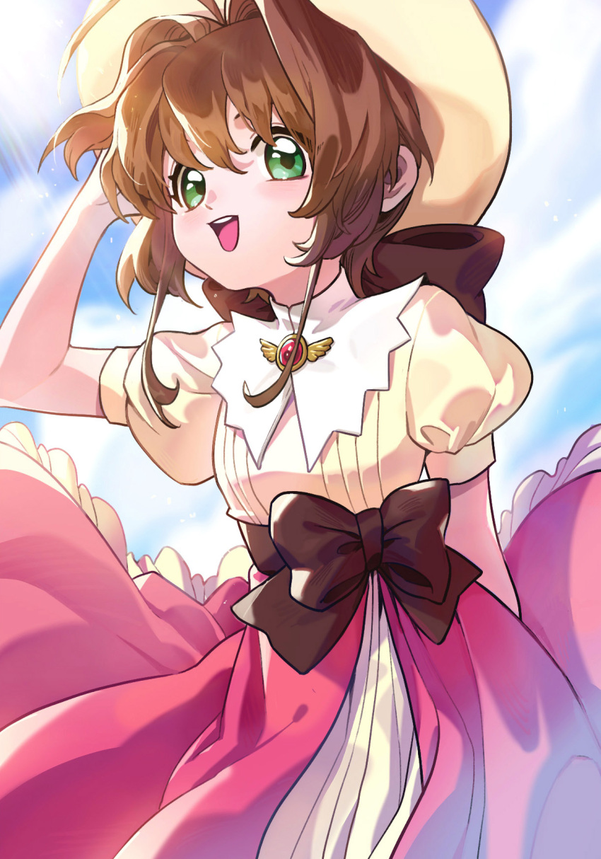 1girl antenna_hair bangs bow brooch brown_hair brown_ribbon cardcaptor_sakura day dress female_child green_eyes hat highres holding holding_clothes holding_hat jewelry kinomoto_sakura kuzen looking_at_viewer magical_girl open_mouth pink_dress puffy_short_sleeves puffy_sleeves red_brooch ribbon short_hair short_sleeves smile solo sunlight white_headwear