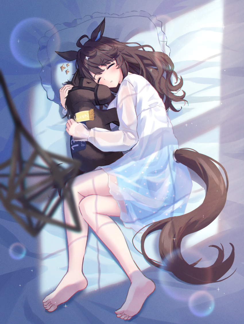 1girl ahoge animal_ears barefoot bed_sheet blurry blurry_foreground blush brown_hair closed_eyes daring_tact_(umamusume) dress highres horse_ears horse_girl horse_tail kashmir_0808 long_hair long_sleeves lying on_side parted_lips pillow see-through see-through_dress sleeping solo stuffed_animal stuffed_horse stuffed_toy tail toes umamusume