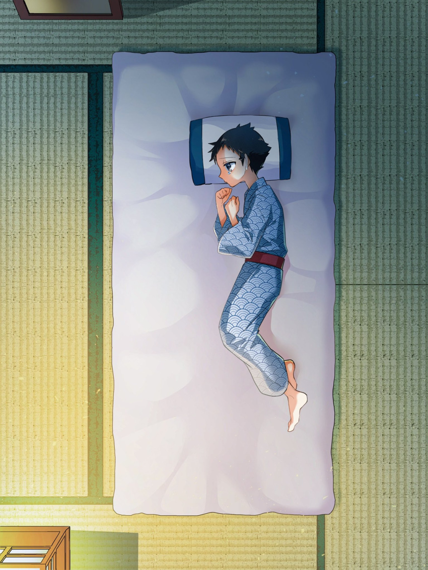 1boy barefoot black_hair blue_kimono closed_mouth commentary_request from_above from_side full_body futako_(gemini_ds) futon hands_up highres indoors japanese_clothes kimono light lying male_focus on_side pillow pokemon pokemon_(game) pokemon_legends:_arceus rei_(pokemon) sad sash short_hair solo tatami tearing_up