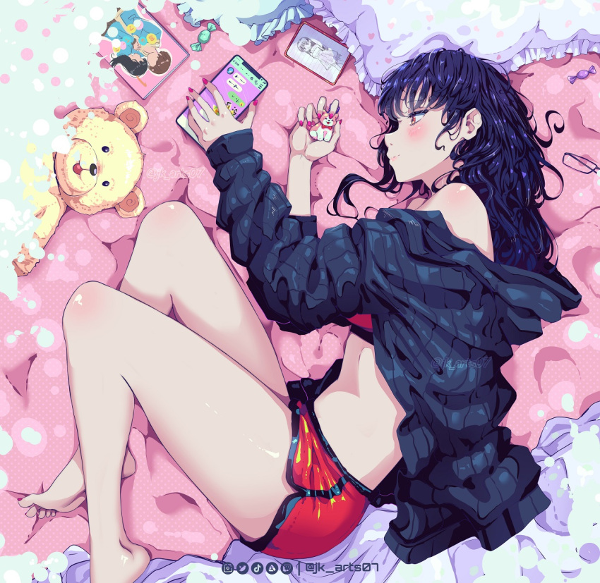 1girl ass bare_shoulders barefoot bed_sheet blue_hoodie blush boku_no_kokoro_no_yabai_yatsu candy cellphone closed_mouth eyewear_removed feet_out_of_frame food frilled_pillow frills highres hood hoodie jk_arts keychain long_hair lying manga_(object) messy_hair off-shoulder_sweater off_shoulder on_side open_clothes open_hoodie phone picture_(object) pillow red_shorts red_sports_bra shorts smartphone solo sports_bra stuffed_animal stuffed_toy sweater teddy_bear thighs twitter_username yamada_anna yellow_eyes