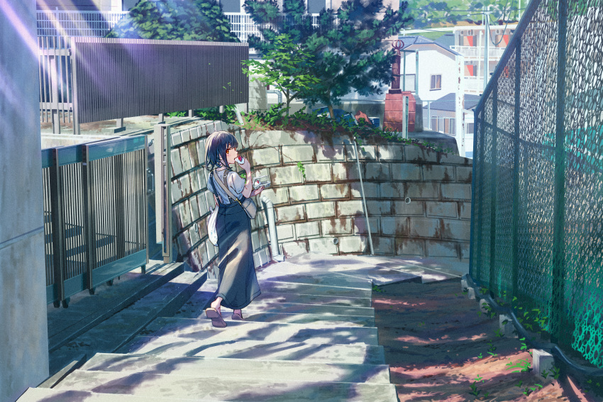 1girl absurdres apartment bag black_hair black_skirt brown_eyes building chain-link_fence city commentary_request dappled_sunlight eating fence food highres holding holding_food long_skirt looking_at_viewer looking_back michinoku_(hiking_miusan18) original overall_skirt pink_footwear scenery shadow shirt shoulder_bag skirt solo stairs standing stone_wall sunlight tree walking wall white_shirt window