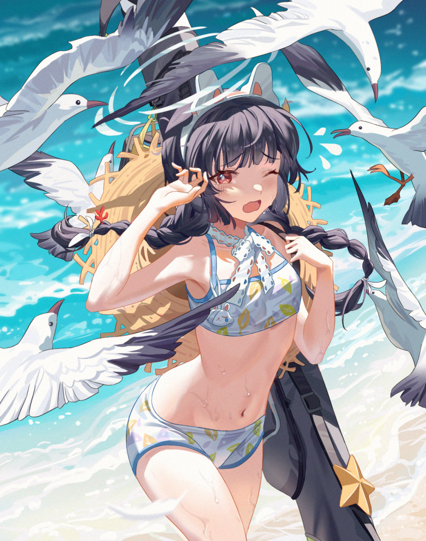 1girl beach bird black_hair blue_archive braid breasts brown_eyes day hairband halo hat hat_around_neck highres leaf_print long_hair miyu_(blue_archive) miyu_(swimsuit)_(blue_archive) navel official_alternate_costume one_eye_closed open_mouth outdoors sanmu seagull small_breasts solo sun_hat swimsuit twin_braids