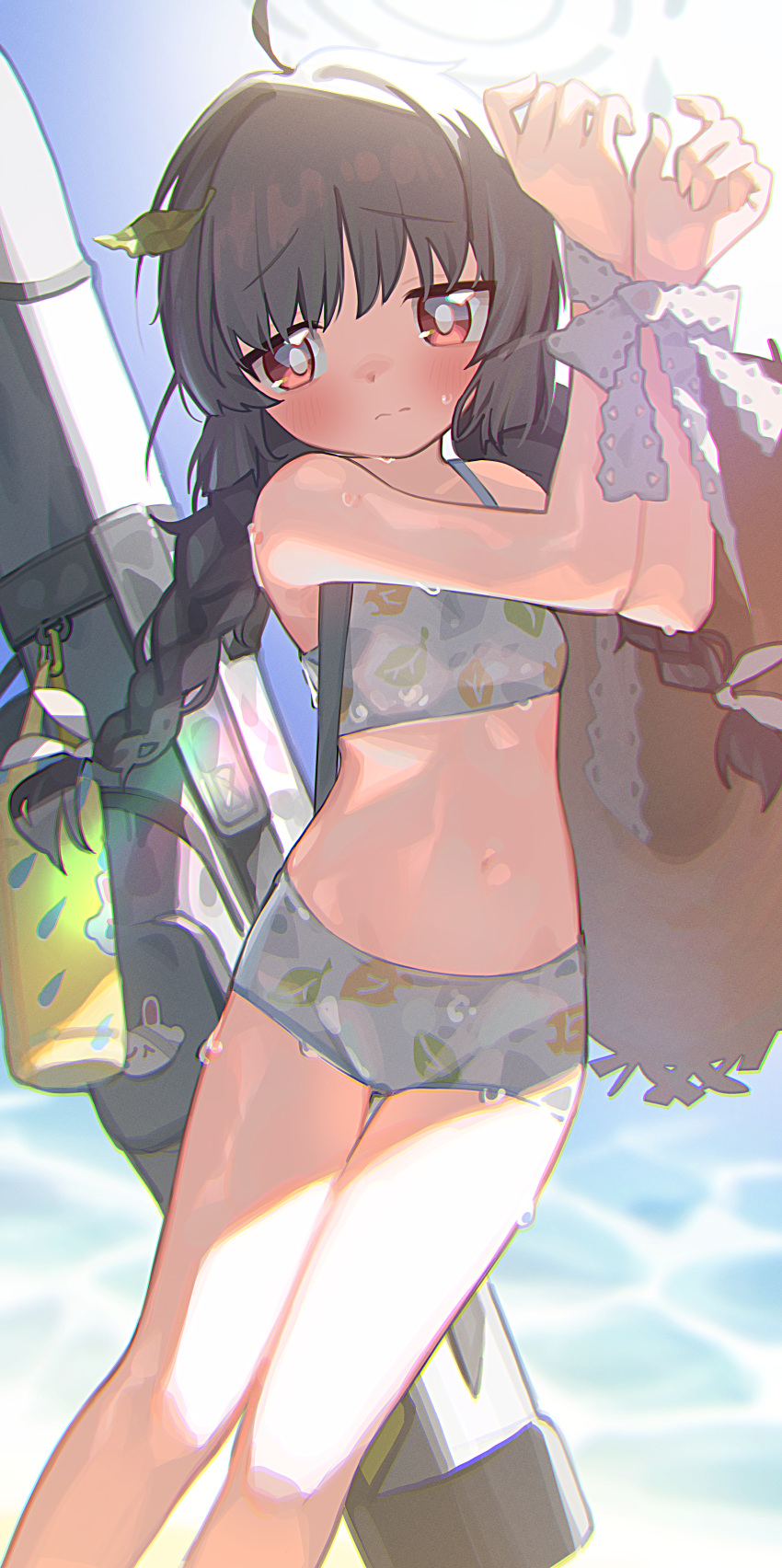 1girl absurdres ahoge bikini black_hair blue_archive blush bottle bound bound_wrists braid closed_mouth day flat_chest hair_ribbon halo hat hat_removed headwear_removed highres leaf leaf_on_head leaf_print long_hair miyu_(blue_archive) miyu_(swimsuit)_(blue_archive) nnmbpx outdoors red_eyes ribbon solo straw_hat swimsuit twin_braids wet