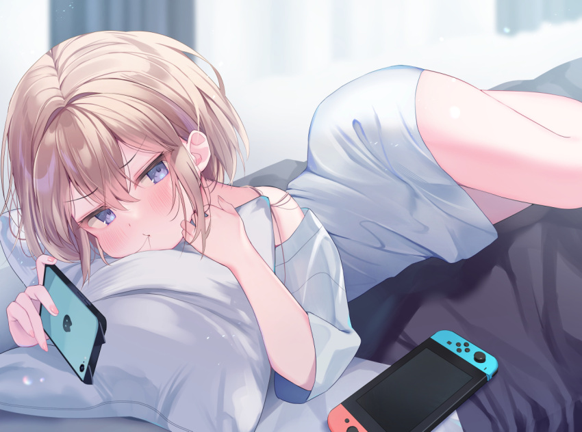 1girl bare_shoulders bed blue_eyes blurry blurry_background blush brown_hair cellphone closed_mouth commentary_request curtains day depth_of_field ebihara_beniko hair_between_eyes hair_in_own_mouth holding holding_phone indoors long_sleeves lying nail_polish nintendo_switch off_shoulder on_bed on_side original phone pillow pink_nails shirt solo white_shirt