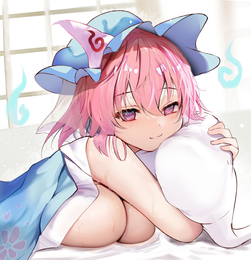 1girl blue_headwear bob_cut breasts cleavage closed_mouth efe hair_between_eyes hat highres hitodama huge_breasts looking_at_viewer lying mob_cap object_hug on_bed on_stomach pillow pillow_hug pink_eyes pink_hair saigyouji_yuyuko smile solo sweat touhou triangular_headpiece under_covers
