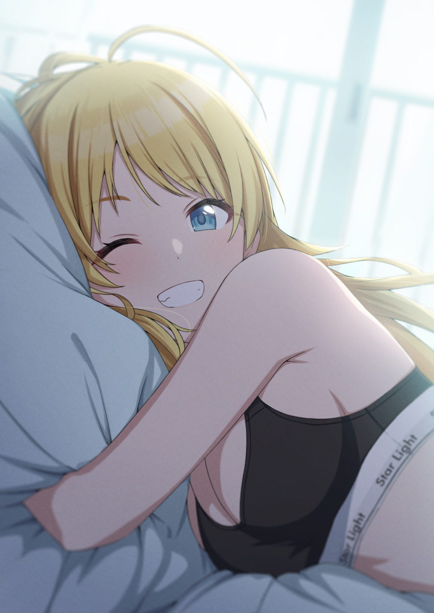 1girl ahoge amochin bare_shoulders bed bed_sheet black_bra blonde_hair blue_eyes blush bra breasts cleavage clothes_writing commentary_request grin hachimiya_meguru highres idolmaster idolmaster_shiny_colors large_breasts long_hair looking_at_viewer lying object_hug on_bed on_side one_eye_closed pillow pillow_hug smile solo teeth underwear underwear_only