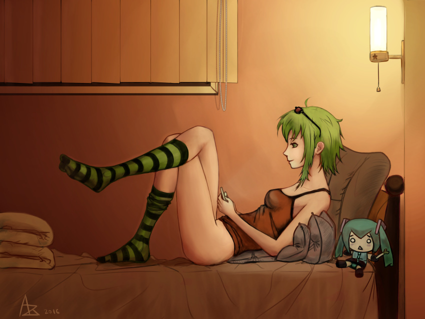 1girl bare_arms bare_hips bare_legs bed bed_sheet bedroom brown_tank_top cellphone collarbone crossed_legs curtains doll goggles goggles_on_head green_eyes green_footwear green_hair gumi hachune_miku hatsune_miku highres holding holding_phone kneehighs light looking_at_phone night non-web_source on_bed on_pillow phone pillow relaxing short_hair smile socks striped striped_socks tank_top window