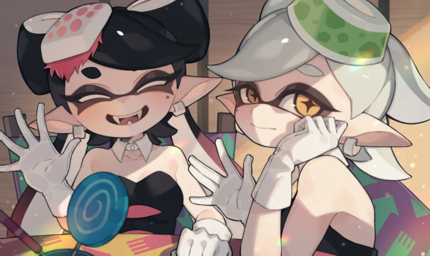 2girls black_dress black_hair callie_(splatoon) candy detached_collar dress earrings fangs food gloves grey_hair highres indoors jewelry lollipop looking_at_viewer marie_(splatoon) mole mole_under_eye multiple_girls open_mouth pointy_ears prat_rat smile splatoon_(series) strapless strapless_dress swirl_lollipop table tentacle_hair yellow_eyes