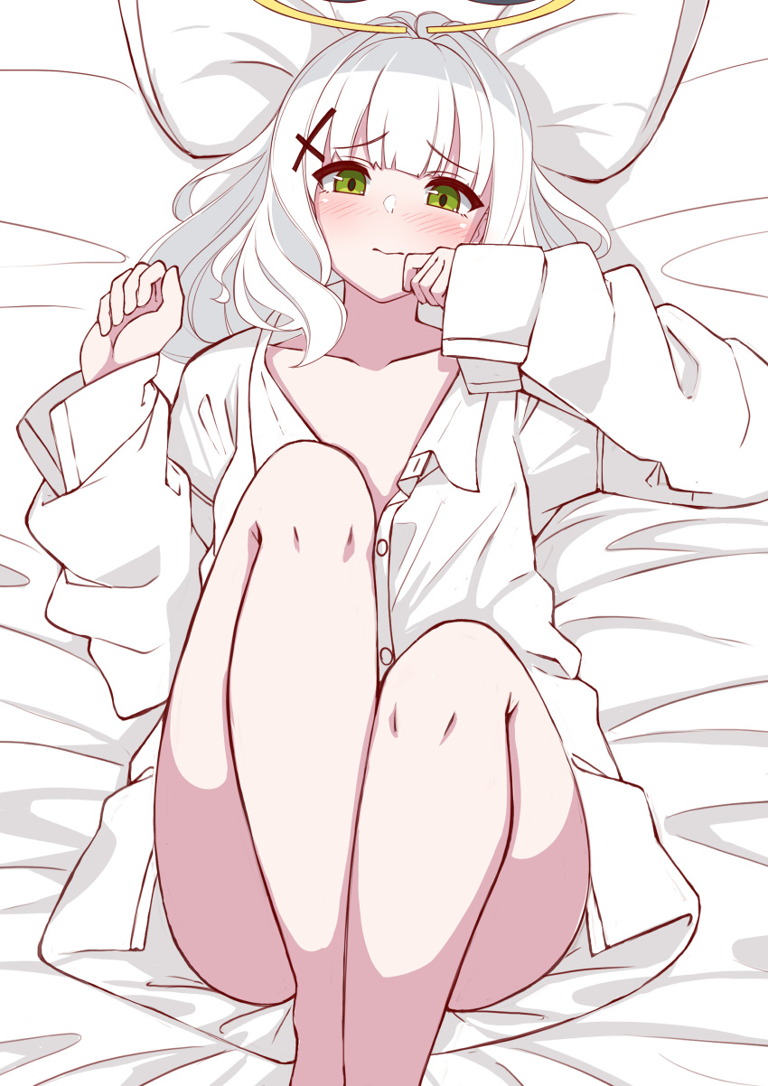 1girl absurdres ass bed_sheet blue_archive blush buttons closed_mouth collarbone cross_hair_ornament feet_out_of_frame flat_chest green_eyes grey_hair hair_ornament halo hare_(blue_archive) highres long_hair looking_at_viewer moyoron pillow shirt solo white_shirt