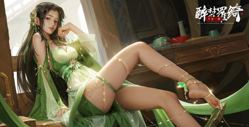 1girl absurdres anklet baiguio_(zhu_xian) bare_legs bare_shoulders barefoot bowl brown_hair butterfly_hair_ornament chinese_clothes dress facial_mark forehead_mark green_dress hair_ornament highres jewelry leg_up long_hair sang_de_lan_de_dengdai sash second-party_source sitting solo table thread zhu_xian