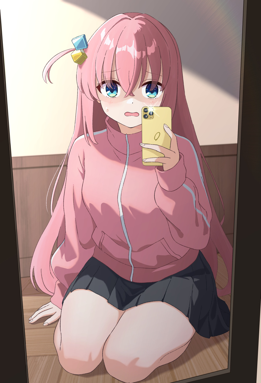 1girl absurdres black_skirt blue_eyes blush bocchi_the_rock! commentary_request cube_hair_ornament gotou_hitori hair_between_eyes hair_ornament highres holding holding_phone indoors jacket long_hair long_sleeves looking_at_viewer mirror parted_lips phone pink_hair pink_jacket pink_track_suit pleated_skirt pogeepoge selfie sitting skirt solo track_jacket wariza