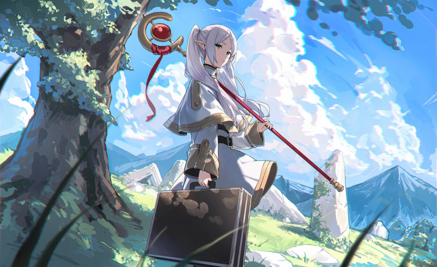 1girl belt belt_buckle black_belt blue_sky buckle capelet closed_mouth cloud day elf floating_hair frieren gold_trim grass green_eyes highres holding holding_staff holding_suitcase long_hair long_sleeves looking_at_viewer mage_staff mountainous_horizon outdoors parted_bangs pointy_ears rock shadow shirt skirt sky solo sousou_no_frieren staff suitcase tree twintails white_capelet white_hair white_shirt white_skirt yohaku