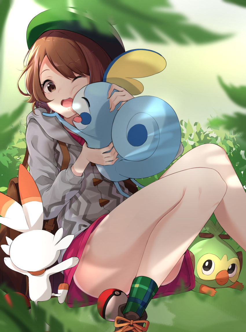 1girl :d absurdres backpack bag brown_bag brown_eyes brown_footwear brown_hair cardigan dress gloria_(pokemon) green_headwear green_socks grey_cardigan grookey hat highres holding holding_pokemon hood hood_down hooded_cardigan korean_commentary on_grass one_eye_closed open_mouth outdoors pink_dress plaid_socks poke_ball poke_ball_(basic) pokemon pokemon_(creature) pokemon_(game) pokemon_swsh scorbunny short_hair sitting smile sobble socks solo tam_o'_shanter ziro_(zirorong)