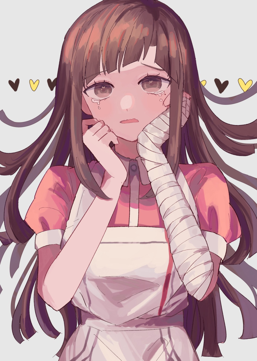 1girl apron bandaged_arm bandages brown_hair collared_shirt commentary_request danganronpa_(series) danganronpa_2:_goodbye_despair grey_background hands_up heart highres ibushi_(kuyuru_29) long_hair mole mole_under_eye pink_shirt puffy_short_sleeves puffy_sleeves shirt short_sleeves simple_background solo tears tsumiki_mikan two-tone_shirt upper_body white_apron white_shirt