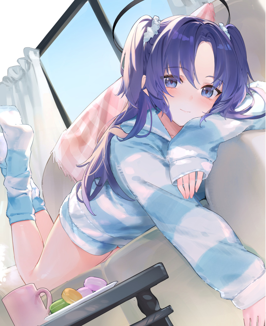 1girl absurdres blue_archive blush closed_mouth commentary_request couch cup feet_up food foot_out_of_frame hair_ornament hair_scrunchie highres isaya_(pixiv4541633) long_hair long_sleeves looking_at_viewer lying macaron no_pants on_couch on_stomach pajamas parted_bangs purple_eyes purple_hair scrunchie sidelocks smile solo table two_side_up yuuka_(blue_archive)