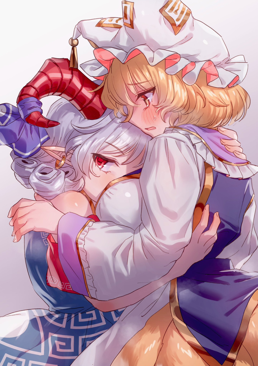 2girls blonde_hair blush bow breasts curly_hair dress earrings fox_tail hat highres horn_ornament horn_ribbon horns hug jewelry long_sleeves masanaga_(tsukasa) mob_cap multiple_girls multiple_tails open_mouth pointy_ears red_eyes red_horns ribbon sheep_horns short_hair short_sleeves simple_background tail touhou toutetsu_yuuma white_hair yakumo_ran yuri