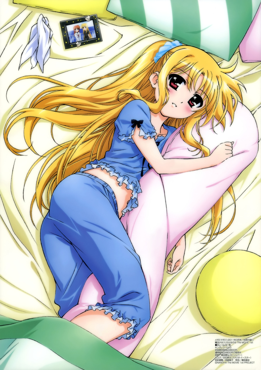 absurdres bed bed_sheet blonde_hair blush body_pillow fate_testarossa highres long_hair lying lyrical_nanoha mahou_shoujo_lyrical_nanoha mahou_shoujo_lyrical_nanoha_the_movie_1st megami non-web_source official_art okuda_yasuhiro on_side pajamas photo_(object) pillow ponytail red_eyes solo takamachi_nanoha very_long_hair