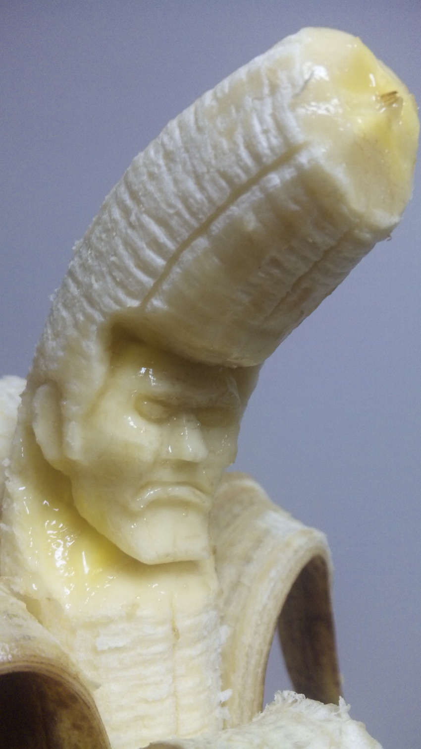 banana commentary_request delinquent food frown fruit highres male_focus manly original photo pompadour sculpture solo suu_(banana) unconventional_media